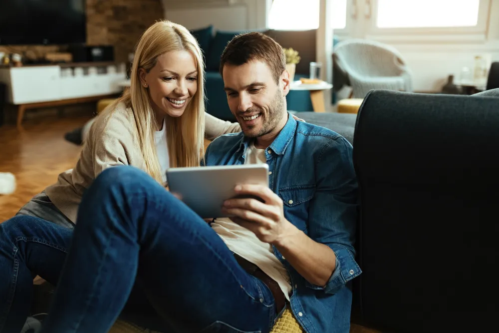 Paar nutzt im Wohnzimmer ein Tablet